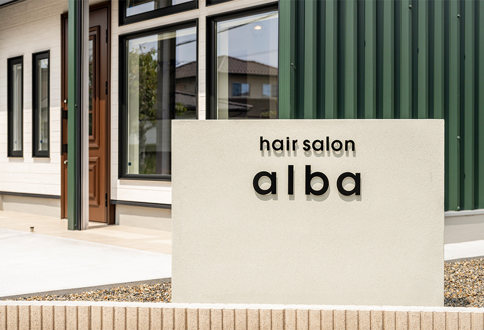 外観のグリーンとのコントラストが映えるサイン