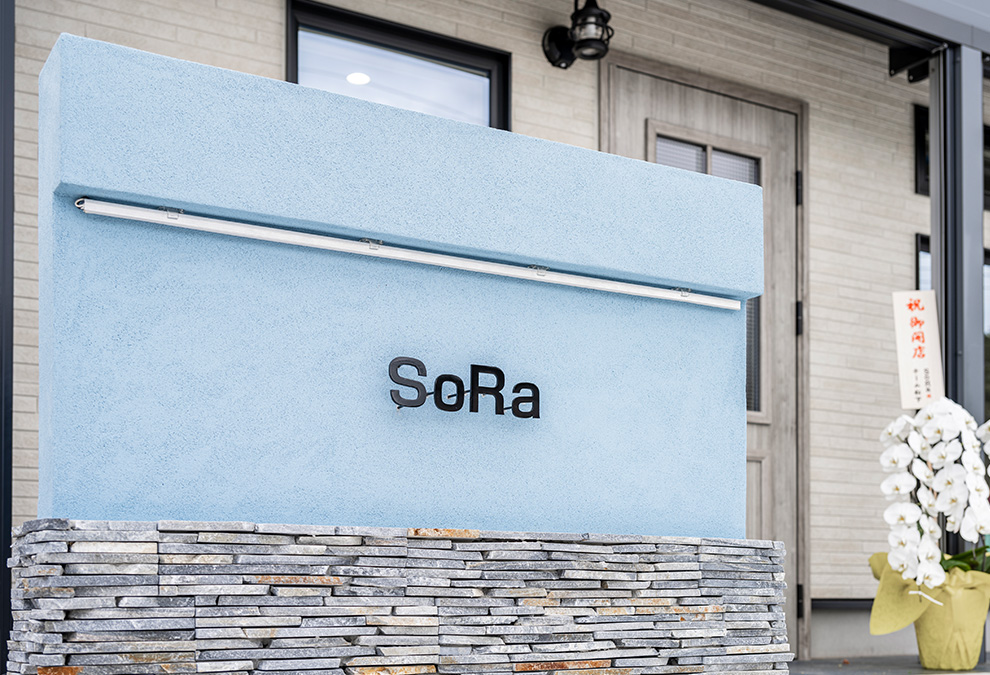 石積みの質感とブルーのサインでサロンの個性と想いを描く