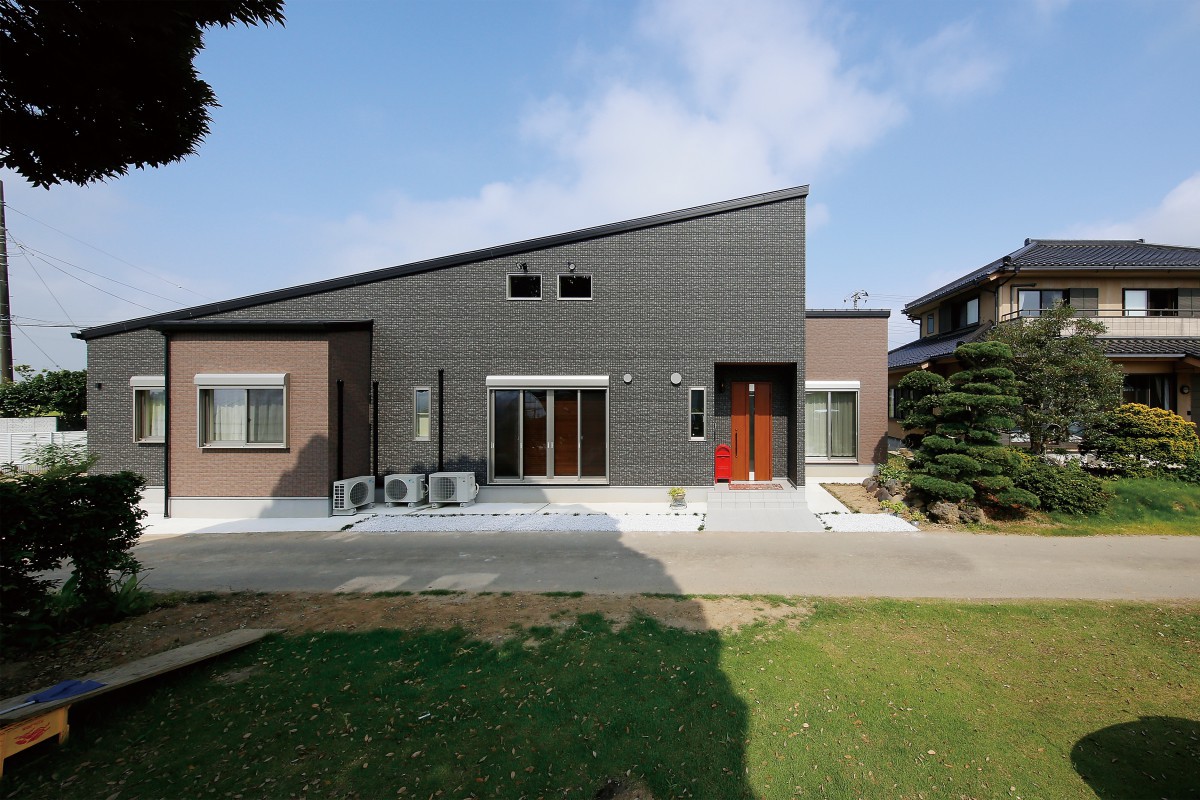 片流れの大屋根が印象的な平屋。外壁は黒とベージュでシックにまとめた。