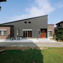 片流れの大屋根が印象的な平屋。外壁は黒とベージュでシックにまとめた。