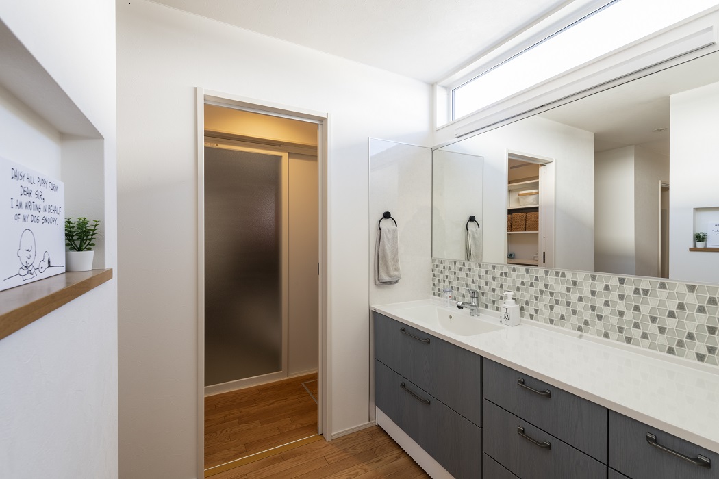 洗面化粧台はPanasonicのシーラインを採用。造り付けを検討しながらも何度もショールームへ行って納得して決めたとのこと。洗面室と廊下の間は扉をあえて設けずに帰宅後の手洗い動線を確保ししました。