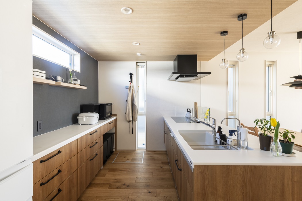 パントリー代わりにカップボードを横に広く設け、収納スペースを確保しました。また、奥様の身長を考慮して吊戸棚は付けずにオープンなスペースに。