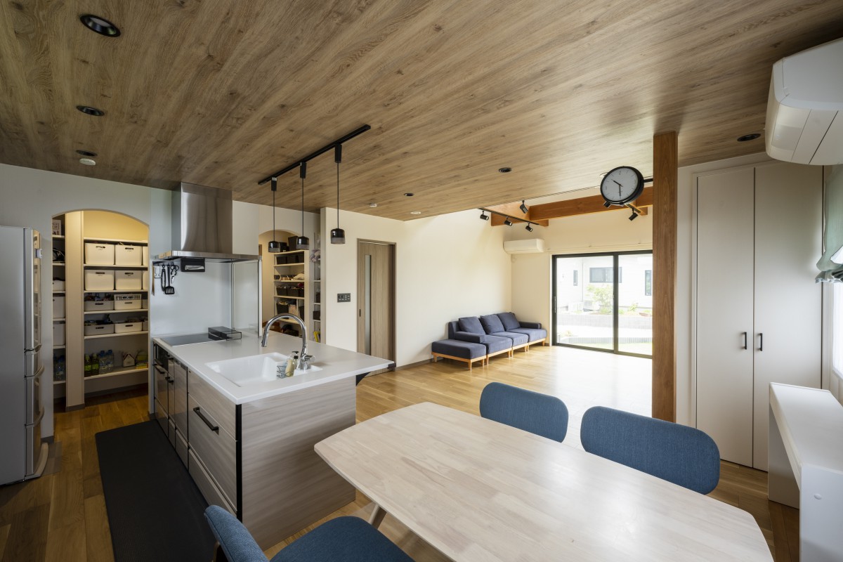 木目の下がり天井で、リビングとは空間をゆるやかに分けたダイニングキッチン。