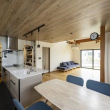 木目の下がり天井で、リビングとは空間をゆるやかに分けたダイニングキッチン。