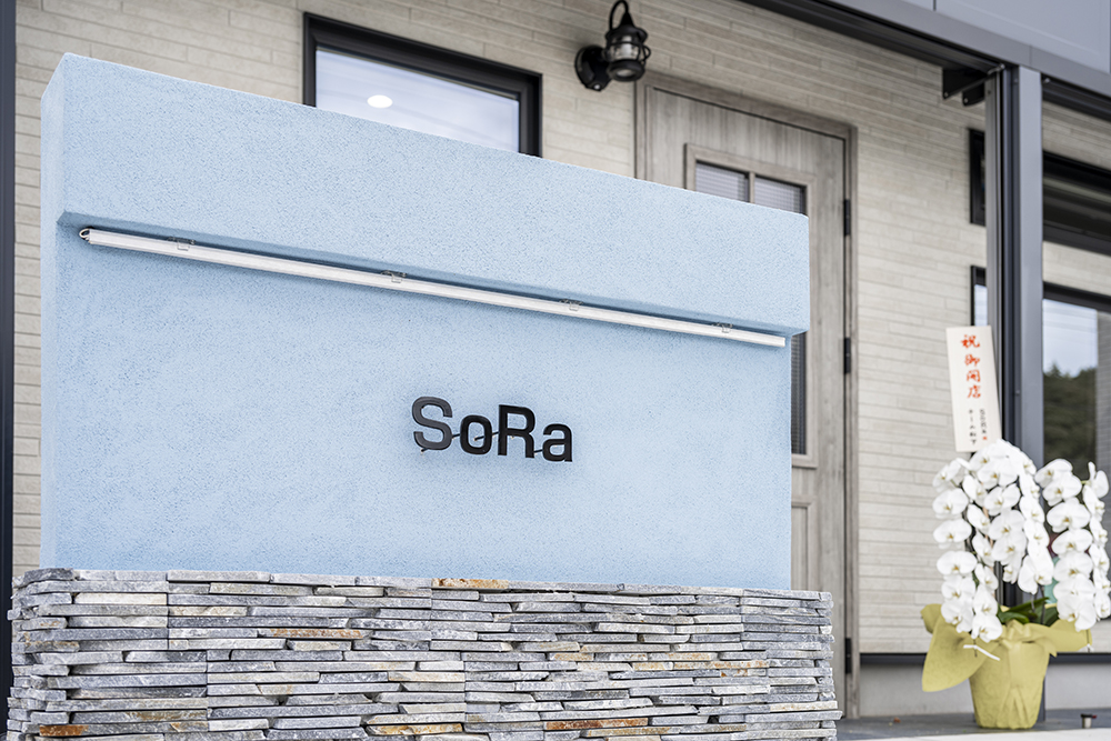 石積みの質感とブルーのサインでサロンの個性と想いを描く