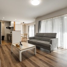 大きい窓からひざしが差し込む居心地の良い明るいリビング