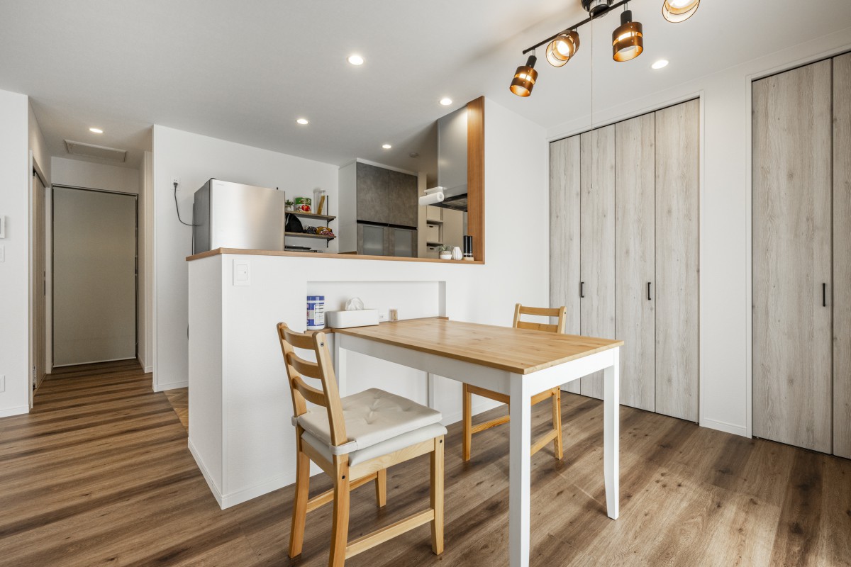 おしゃれなスポット照明のあるダイニングスペース。壁面にはたっぷりしまえるリビング収納