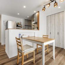 おしゃれなスポット照明のあるダイニングスペース。壁面にはたっぷりしまえるリビング収納