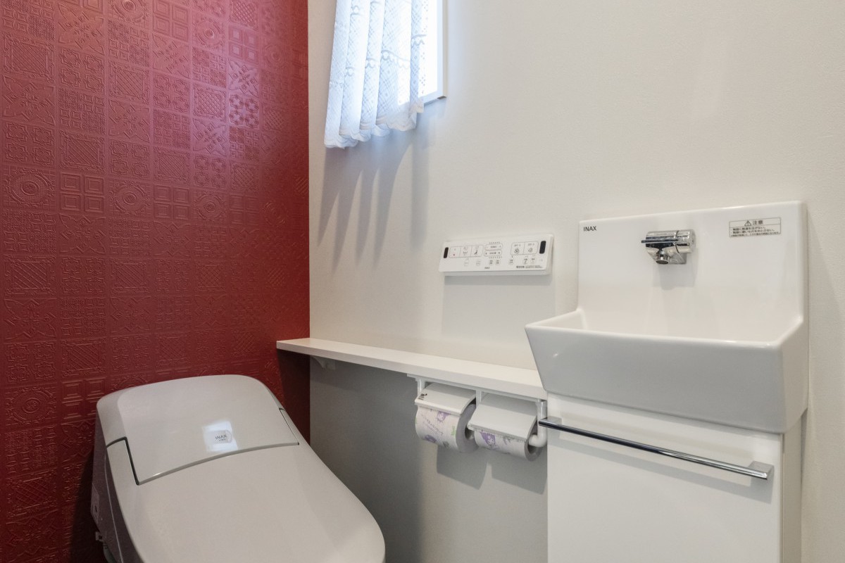赤のアクセントが映える、スタイリッシュなトイレ空間