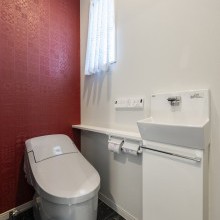 赤のアクセントが映える、スタイリッシュなトイレ空間