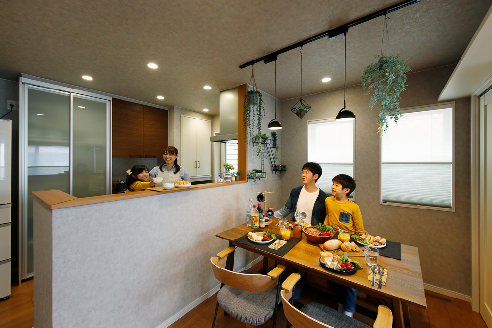 会話のはずむキッチン　ライティングレール　ハンキンググリーン　食卓　ダイニング　手元が隠れるキッチン　食器棚　カップボード　ダウンライト　ペンダントライト　