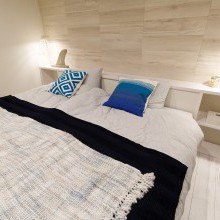 白いお部屋　ナチュラルテイスト　明るい寝室　ベッドライト　ダブルベッド　リゾートチック　ホワイトペイントフローリング　木目パネル　